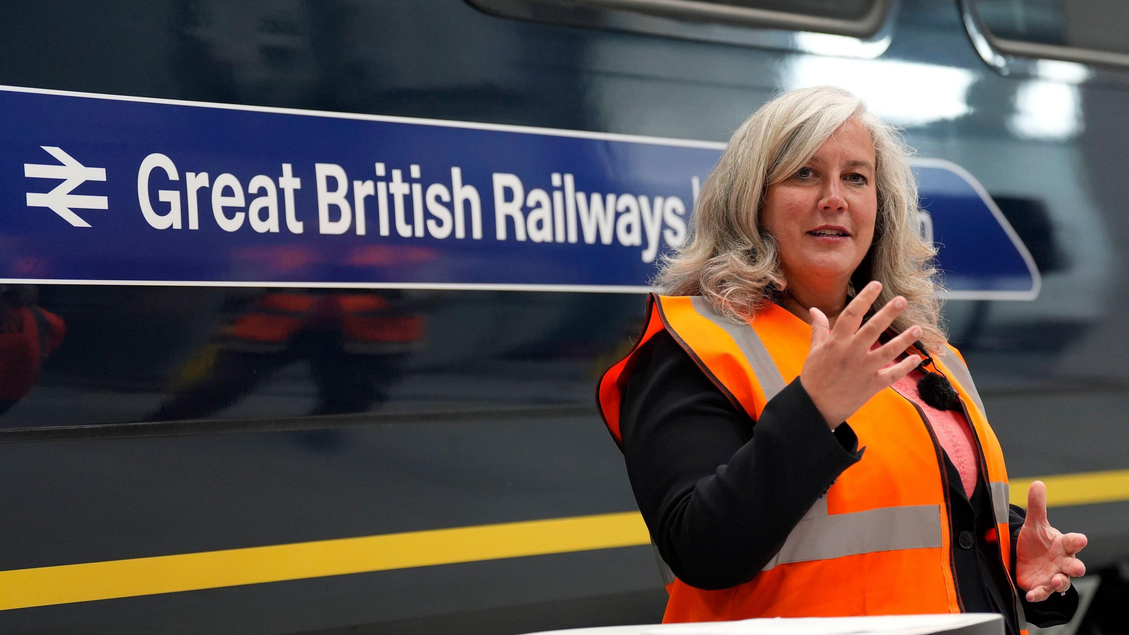 Transport Secretary Heidi Alexander speaking in front of a Great British Railways train